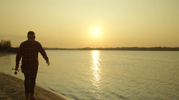 Male Angler Walking on Lake Shore at Dawn