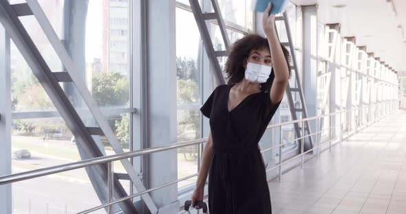 Beautiful African American Girl with Curly Hair in Black Clothes Wears Medical Mask on Her Face alt