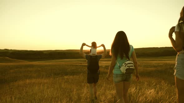 Teamwork Travelers. Family with Children Travels on the Plains and Mountains. Father Carries a alt