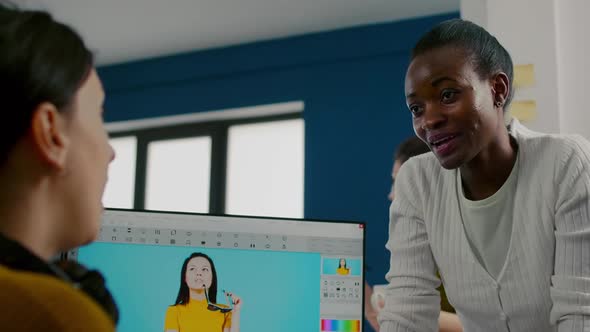 Team of Multiethnic Retouchers Working with Modern Photo Editing Software alt