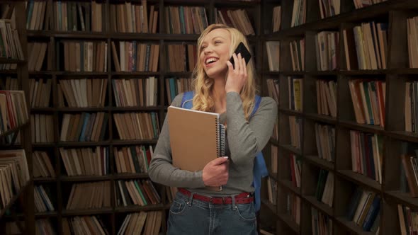 Female Student Talking on the Phone and Laughing in the Library alt