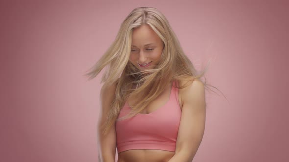 Blond Model in Studio on Pink Background with Hair Blowing in Air