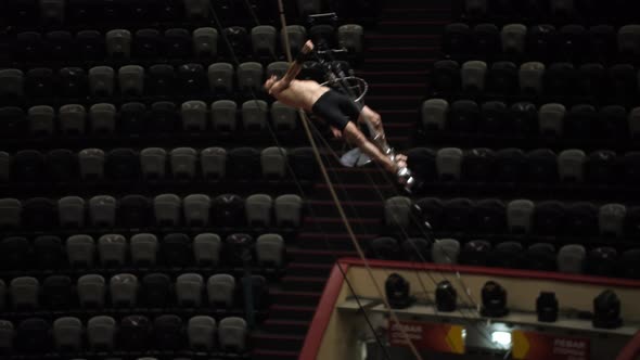 Acrobatic Man Flying Around on Rotating Performance at the Circus Arena alt