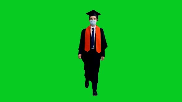 Graduating Student In Protective Mask And Black Gown Walking Towards The Camera