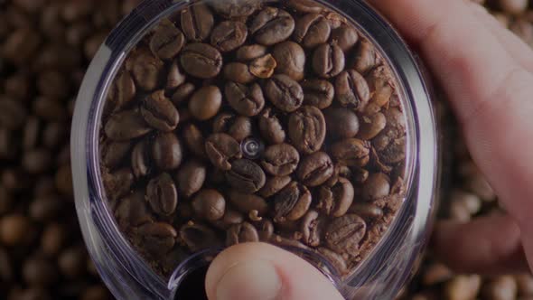 Hand Hold Working Coffee Grinder Close Up Top View alt