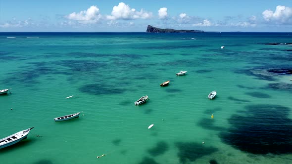 Dolly slow aerial forward shot of boats on crystal clear indian ocean in summer alt