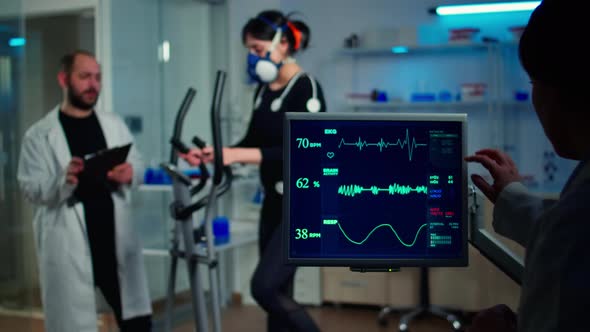 Specialist Sport Researcher Monitoring Heart Rate on Athlete alt