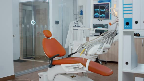 Revealing Shot of Orthodontic Chair with Nobody in Teeth x Ray Images on Modern Display alt