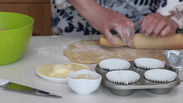 The Woman Rolls Out The Dough. Prepares Cruffin With Raisins And Candied Fruit. alt