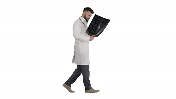Doctor From Middle East Walking and Looking at Ct Scan on White Background. alt