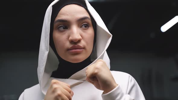 Arab Athlete a Muslim Standing in the Pose of a Fighter Boxing in a Fitness Center Wearing a White alt