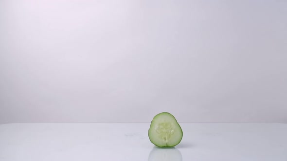 A Woman's Hand Places a Transparent Bottle with a Refreshing Cucumber Face Tonic on a White Table a