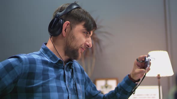 Man in headphones speaks by video connection through smartphone in office