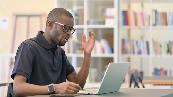 Shocked Young African Man Reacting To Failure in Library alt