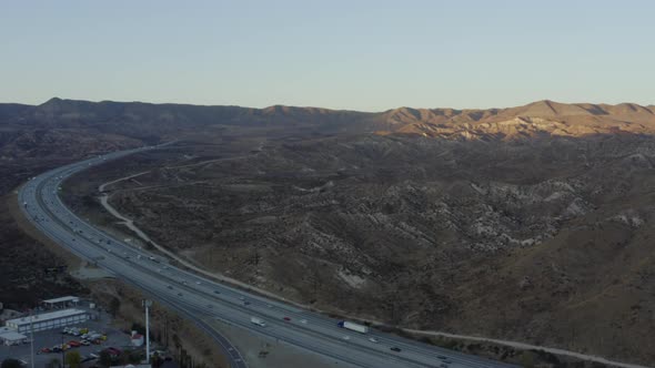 AERIAL: Highway in California Countryside with Mountains at Beautiful Sunset  alt