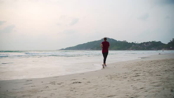 Young Healthy Woman Jogging at the Beach at the Sunrise Time alt