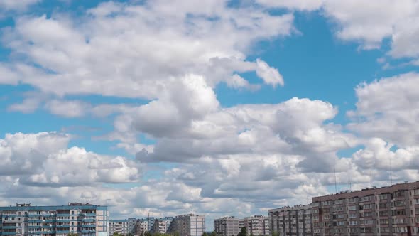 Cumulus Cirrus Clouds Move in the Blue Sky Over Multi-story Buildings in City alt