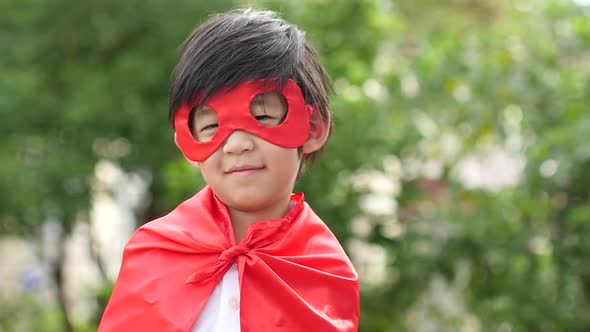 Asian Child In In Superhero Costume Playing In The Park alt