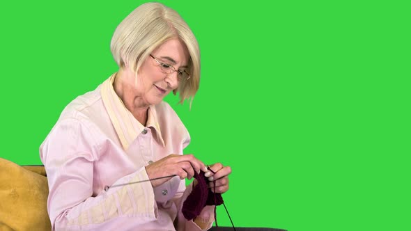 Senior Knitting on a Chair on a Green Screen Chroma Key alt
