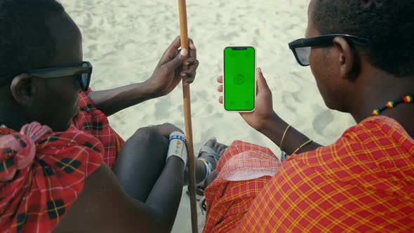 Masai Tribe Men Looking at the Smartphone Green Screen in the Front of Desert
