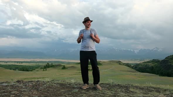 Portrait of a smiling male tourist on a hike summer landscape