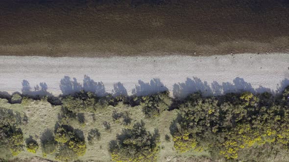 Bird's Eye View of Empty Pebble Shores of a Lake Aerial Flyover alt