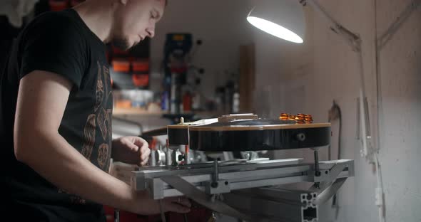 Guitar Tech Mounts the Electric Guitar on the Jig at the Musical Instruments Repairing Shop 60p 10 alt