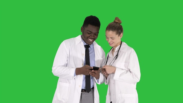 Medical team looking at phone together on a Green Screen alt