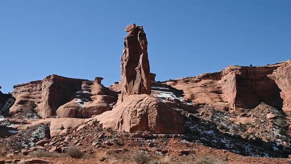 Driving past Sheep Rock in Arches National Park during the day alt