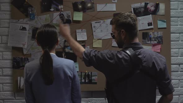 Secret Agency Teammates Searching for Criminal Movements on Investigation Board alt