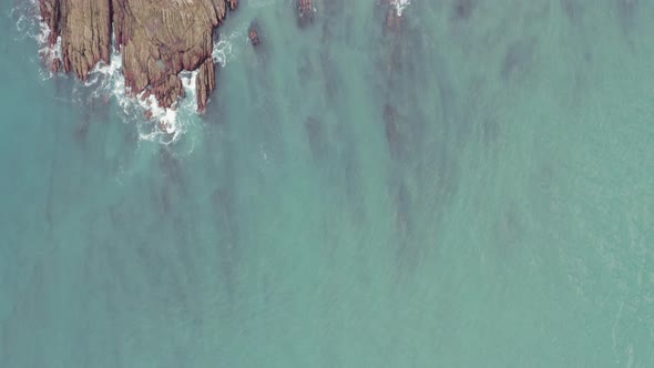 Aerial; top down view of sea coast with beautiful stones and turquoise water, Plentzia, Spain