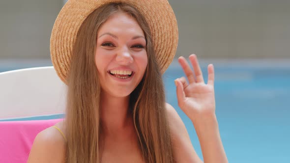 Happy Caucasian Woman in Fashionable Straw Hat Gesturing Ok Smiling with White Teeth Looking at alt