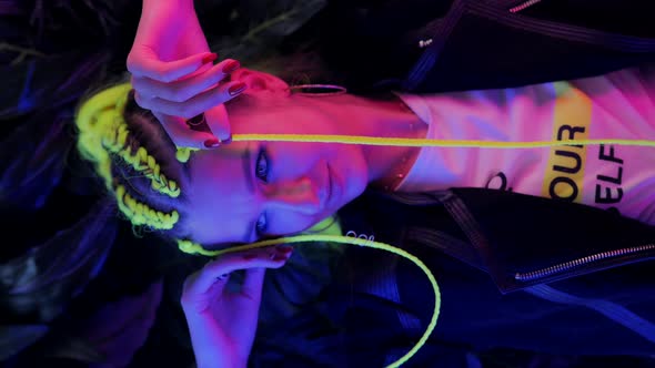 Millennial Young Woman with Yellow Hair in Trendy Neon Pink and Blue Lights alt