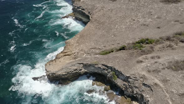 Pulling-In Drone Shot of the Panoramic Scenery of the Ocean Water and Rocky Cliffs alt