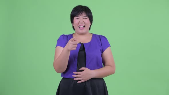 Happy Young Overweight Asian Woman Laughing and Pointing at Camera alt