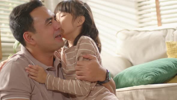 Happy little Asian Cute Girl hugging, embracing her dad
