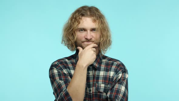 Slow Motion of Attractive European Man with Long Blond Hair Looking Pensive and Touching Beard While