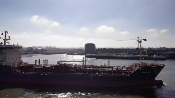 Freight ship navigates near terminal. Commerce concept, aerial view from right alt