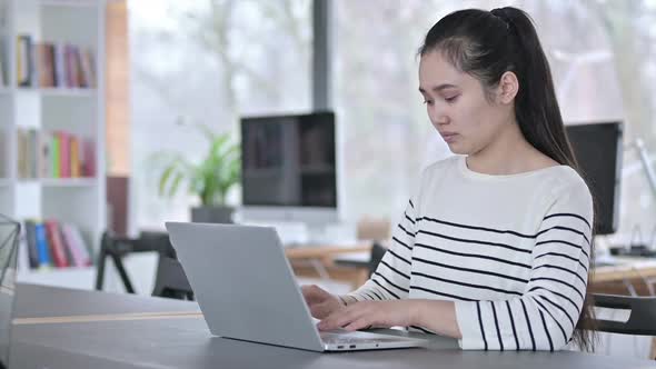 Young Asian Woman Reacting to Loss on Laptop in Office alt