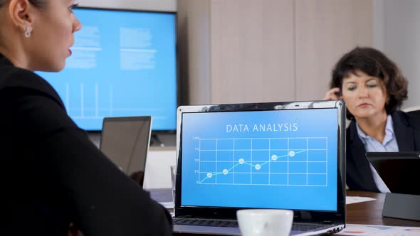 Laptop with Data Analysis in Front of Business Woman alt