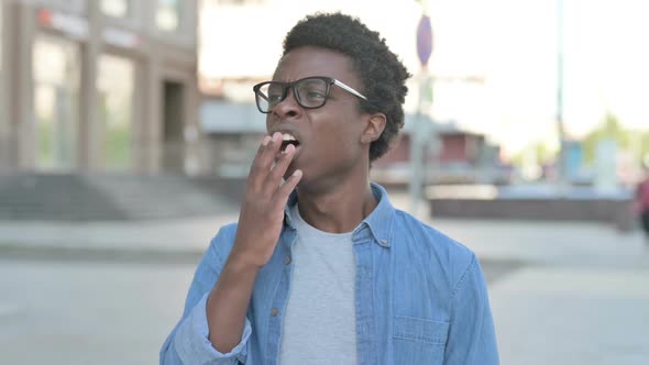 Sleepy Young African Man Yawning Outdoor alt