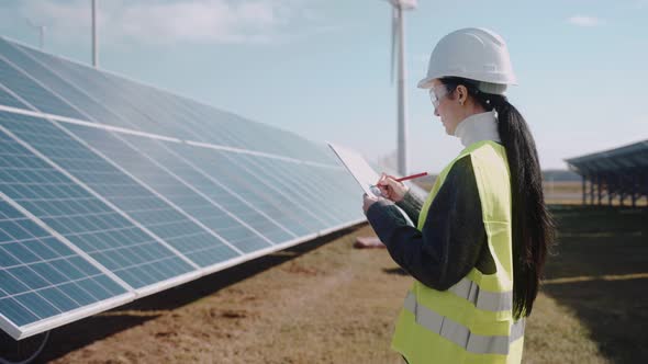 Close Up of Ecological Engineer Collecting Information on a Solar Panel Field