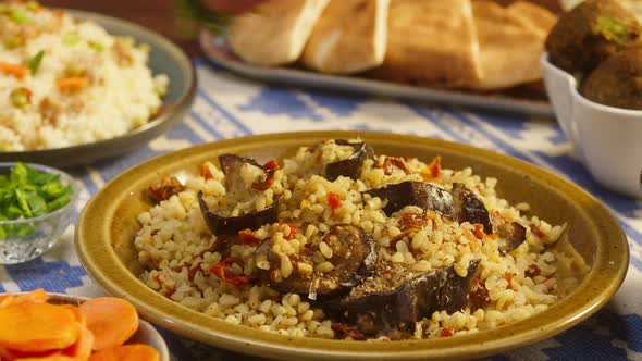 Sprinkling Greenery on Bulgur with Eggplant Closeup Couscous with Meat on Background alt