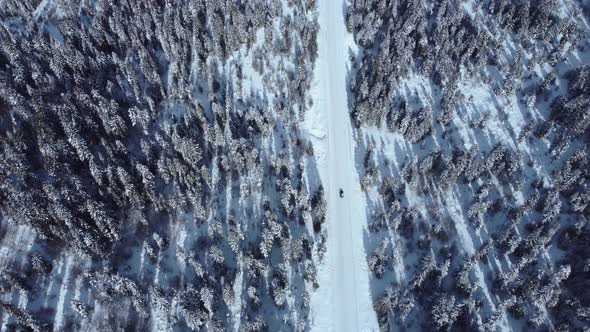 Car is going in the snowy road aerial alt