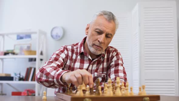 Aging Pensive Male Playing Chess Alone alt