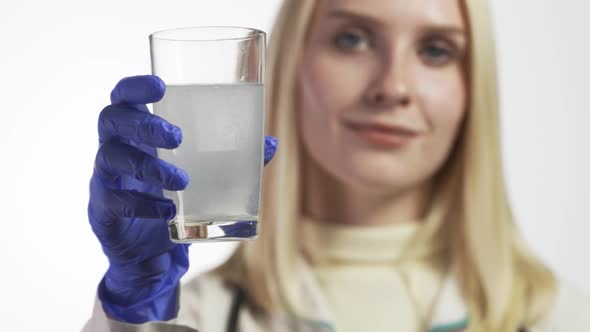 The Doctor Drops the Effervescent Tablet Into the Glass and Dissolves It alt