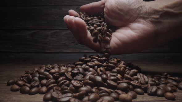 Human Hand touching Roasting brown Coffee Beans with steam. tracking shot, close up