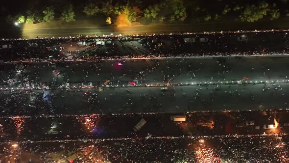 Aerial Birds Eye View Of People Walking Along Road In Karachi At Night For PTI Party Rally On 16 Apr alt