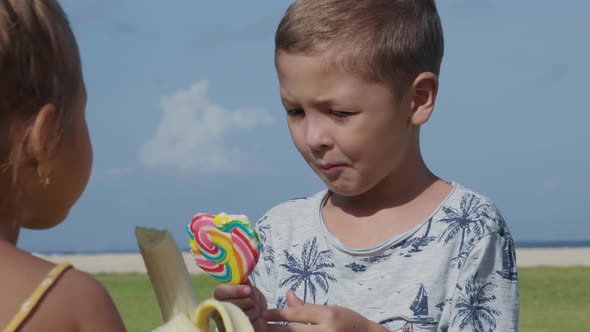 Two Kids Having Bite on Beach alt