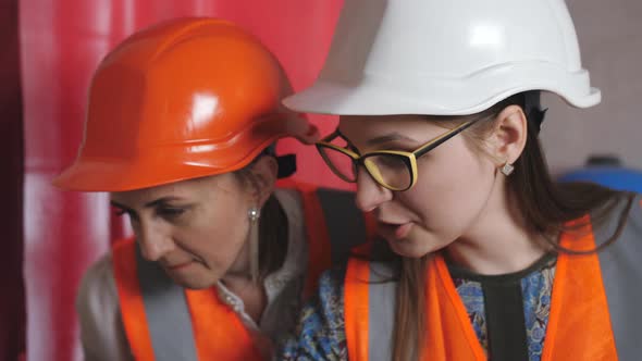Two Woman Engineers Checking Technical Data of Heating System Equipment in a Boiler Room
